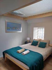 a bedroom with a bed with blue sheets and a window at Le filet Cherbourgeois in Cherbourg en Cotentin