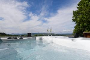 a swimming pool with a view of the mountains at Luxurious Super-king Lodge with hot tub in Langbank