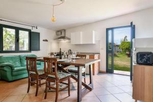 uma cozinha e sala de estar com mesa e cadeiras em Casa vacanze Congiu em Tortolì