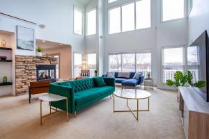 ein Wohnzimmer mit einer grünen Couch und einem Kamin in der Unterkunft Sunny Ridge - Hot Tub, Gym, Jacuzzi Tub, Game Room in Pigeon Forge