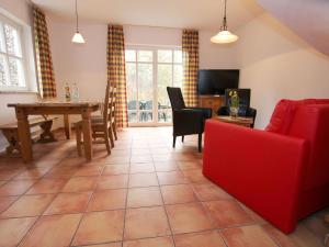 a living room with a red couch and a table at Ferienhaus in Wernigerode mit Innenpool in Wernigerode