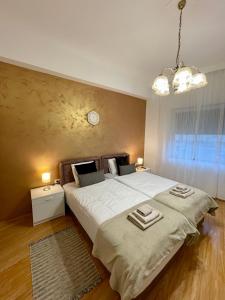 een slaapkamer met een groot bed en een klok aan de muur bij Apartman studio Lusi in Subotica