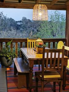 een houten tafel en stoelen op een veranda met een raam bij Wyndover Mountain Retreat in Beechmont