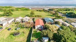 an aerial view of a house on a hill next to the ocean at Le Riva Beachside Haven in Whanganui