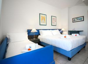two beds in a hotel room with towels on them at Hotel Domus in Marina di Massa