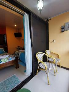 Pokój z 2 krzesłami, łóżkiem i lustrem w obiekcie Cozy Sudio#1, 5min Beach & 1 hour Liberia Int ARPTO w mieście La Cruz