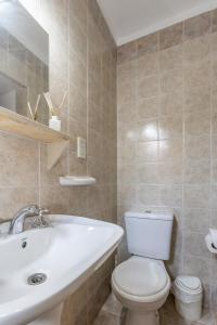 een badkamer met een wit toilet en een wastafel bij Hostel Boutique PASO in Mendoza