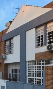 - un bâtiment blanc avec des fenêtres et un bâtiment en briques dans l'établissement Casa Soleada en Calle Tranquila, à Séville