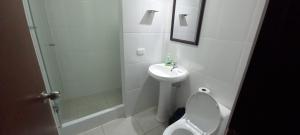a white bathroom with a toilet and a sink at Dpt suite pardo 610 in Lima