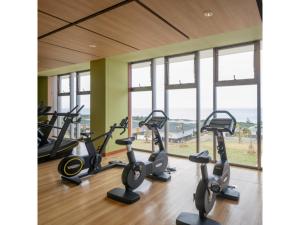 a gym with treadmills and ellipticals and windows at Miyakojima Kurima Resort Seawood Hotel - Vacation STAY 16229v in Uechi