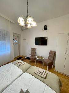een slaapkamer met een groot bed en een tafel en stoelen bij Apartman studio Lusi in Subotica