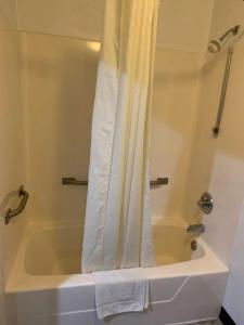 a bathroom with a bath tub with a shower curtain at Super 8 by Wyndham Frankfort IN in Frankfort