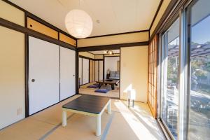 a living room with a table and large windows at Garden Villa Yugawara Kajiya - Vacation STAY 23110v in Mongawa