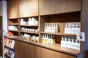 a shelf with many bottles of alcohol on it at Hotel Taiyonoen Tokushima Kenchomae - Vacation STAY 26339v in Tokushima