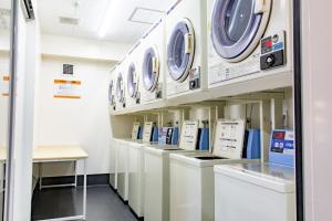 een rij wasmachines en drogers in een wasruimte bij Hotel Taiyonoen Tokushima Kenchomae - Vacation STAY 26358v in Tokushima