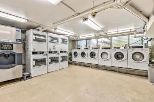 a laundry room with several washing machines and windows at Inviting Waikiki Grand Hotel Room One Block to Beach! in Honolulu