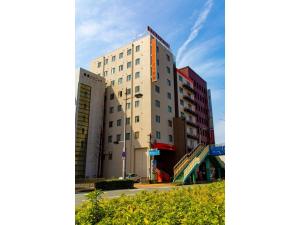 un grand bâtiment blanc dans une rue de la ville dans l'établissement Hotel Taiyonoen Tokushima Kenchomae - Vacation STAY 26340v, à Tokushima