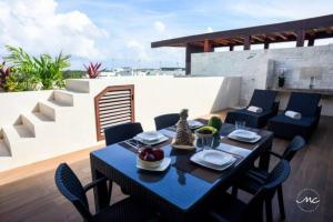 un tavolo da pranzo e sedie su un patio con di Penthouse Blue Luxury La Veleta a Tulum
