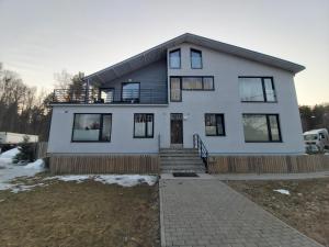 une maison blanche avec des fenêtres noires et une allée. dans l'établissement Viva Apartment - Pirita, à Tallinn