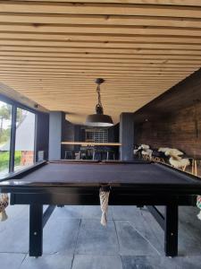 a pool table in a room with a ceiling at La Mansarda Hotel in Urubici