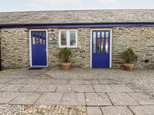 a brick house with blue doors and two potted plants at Wheal Kitty in Newlyn East
