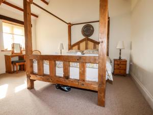 a bedroom with a wooden bed with a wooden frame at Wheal Kitty in Newlyn East