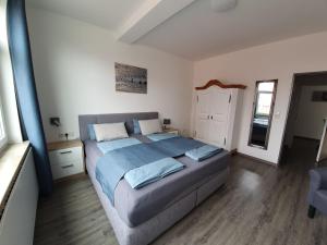 a bedroom with a large bed with blue sheets at Inselkern Einraum-Apartments in Juist