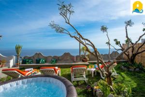 een achtertuin met een hot tub en stoelen bij Casa Francisca in Praiano