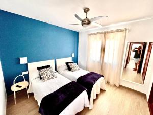 a bedroom with two beds and a ceiling fan at Luxury Suite San Borondón in Playa Honda