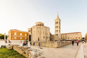 um grupo de pessoas andando em frente a uma igreja em Calle Larga 14 apartment in old town em Zadar