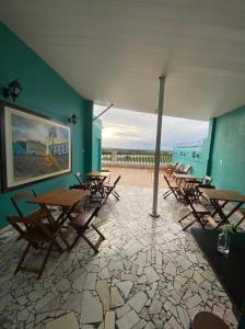 a group of tables and chairs in a room at Pousada Vila do Penedo in Penedo