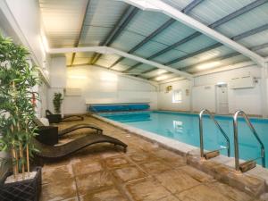 an indoor swimming pool with a large swimming pool at Honeysuckle Cottage in Bude