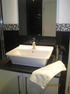a bathroom with a white sink and a mirror at Cames Mead Farmhouse Bed and Breakfast in Mare Green