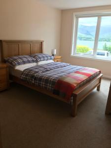 מיטה או מיטות בחדר ב-Borrodale, one bedroom apartment with balcony and loch view.