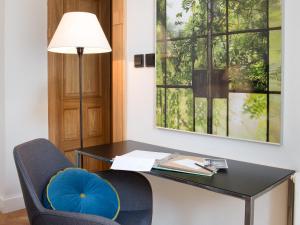 a desk with a blue chair and a lamp at Antique Apartments Plac Szczepański in Krakow