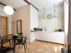 a kitchen and dining room with a table at Antique Apartments Plac Szczepański in Krakow +93 photos