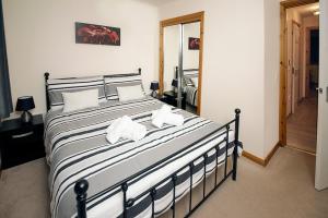 1 dormitorio con 1 cama grande con almohadas blancas en Modern 2 Bedroom Semi detached House with own private driveway, en Inverness