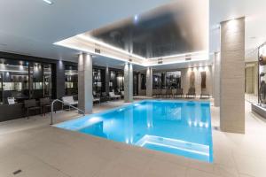 a large swimming pool in a hotel lobby at Best Western Plus Hôtel & Spa de Chassieu in Chassieu