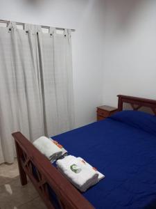 Schlafzimmer mit blauem Bett und weißen Vorhängen in der Unterkunft Cabañas Doña Antonia in San Juan