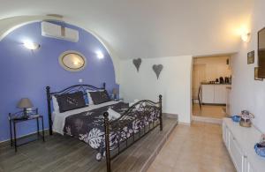 a bedroom with a bed with a blue wall at Galini Apartments Old Town in Rhodes Town