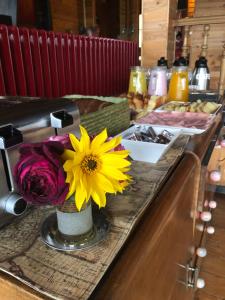 a table with a vase with a yellow flower on it at La Miralejos in San Carlos de Bariloche