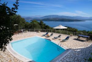 a swimming pool with chairs and a view of a lake at Bellina Villa in Agnítsini