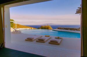 a room with a view of a swimming pool with a window at Villa Zen in Mikonos