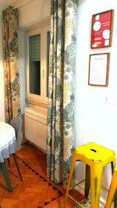 a room with a yellow stool and a window at The sunset Lisbon flat in Lisbon