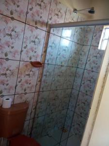 a bathroom with a toilet and flowers on the wall at Hotel Pousada Paraíso Tropical in Salinópolis