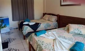 a bedroom with two beds and a tiled floor at Hotel Pousada Paraíso Tropical in Salinópolis +14 photos