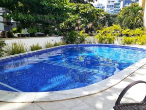 a swimming pool with blue water in a building at Studio encantador em Ondina in Salvador