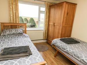 1 dormitorio con 1 cama, vestidor y ventana en Llys Llywenan, en Bodedern