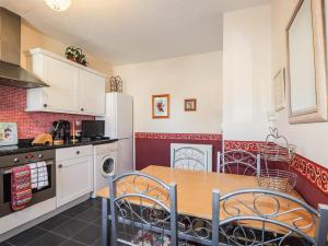 a kitchen with a table and chairs and a refrigerator at Holly Hoose in Findochty