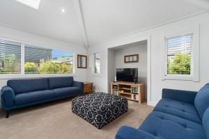 a living room with two blue couches and a tv at Rogers Retreat - Kinloch Holiday Home in Kinloch